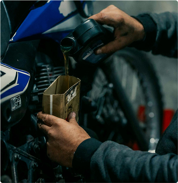 Mechanic pouring oil during bike service